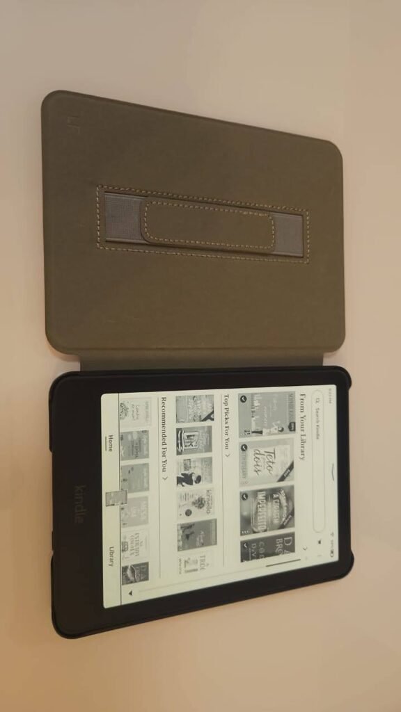 Kindle Paperwhite preto metálico com capa protetora rosa e tela de 7 polegadas, exibindo imagem da tela inicial.